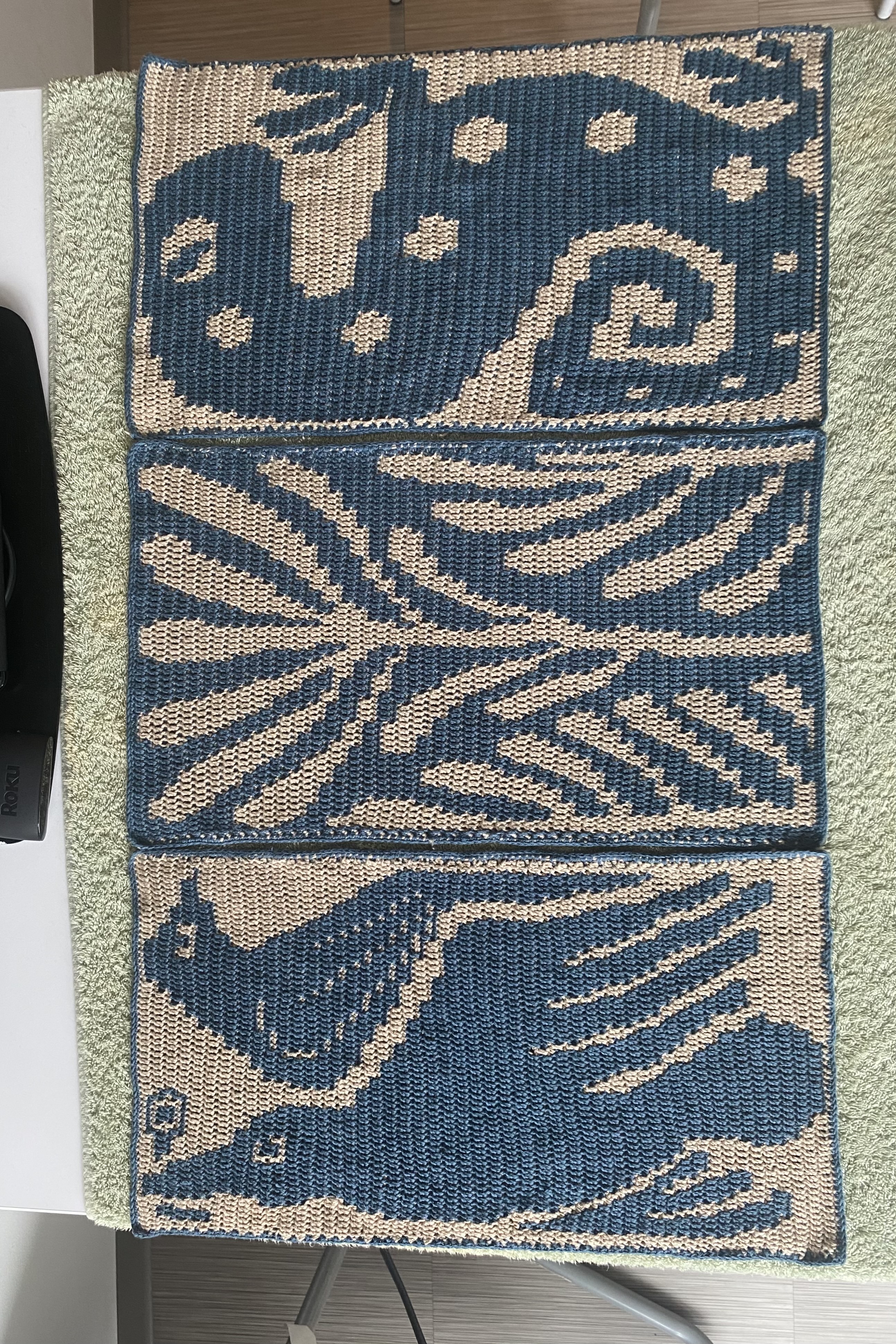 three blue and beige crochet tapestries made one of 2 birds, another of some fern/coral looking plants and the last of a spotted salamander